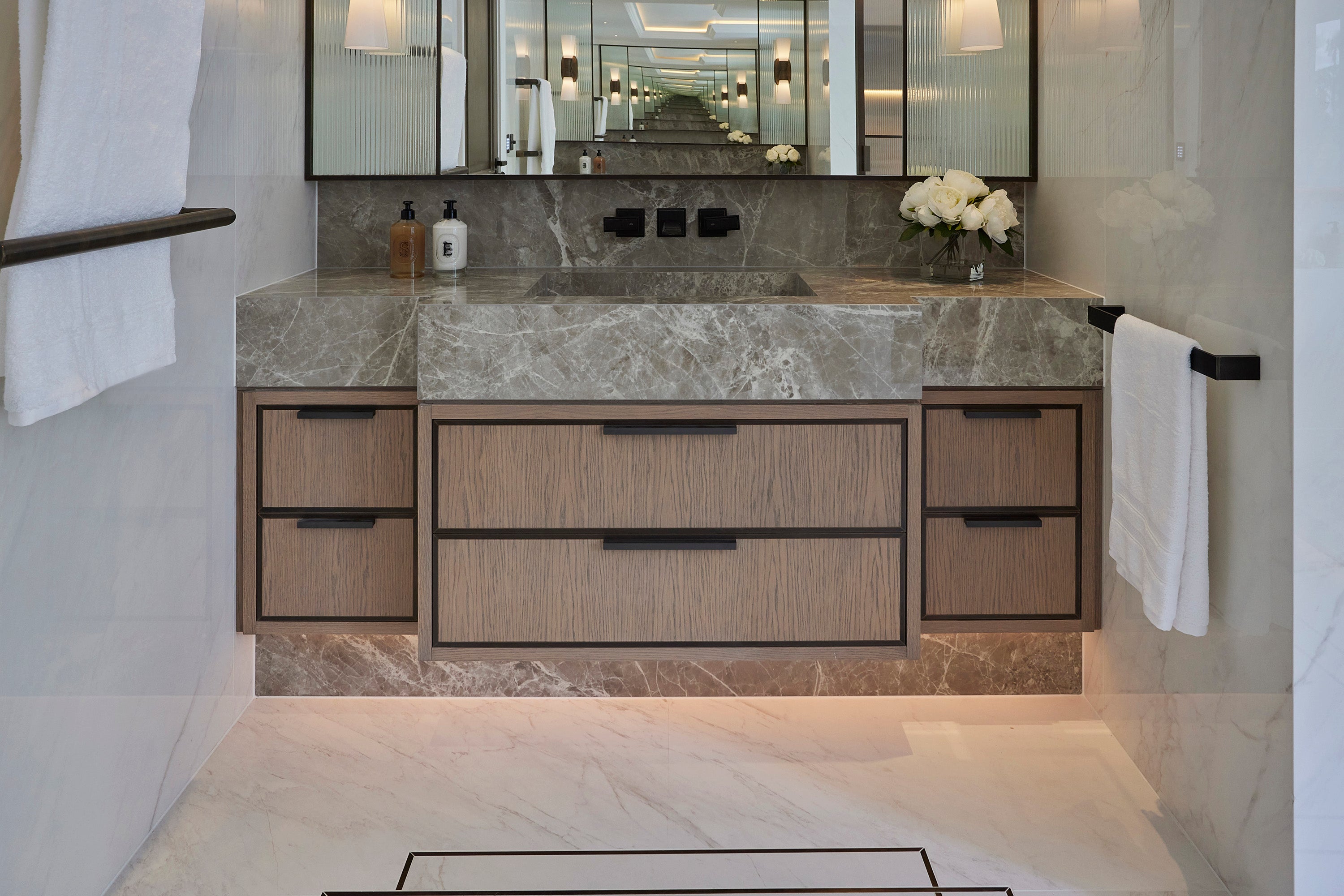 Solid Brass 'Arden' Edge Pull in Dark Bronze. Installed on a Bathroom vanity with marble countertop and wooden cabinets
